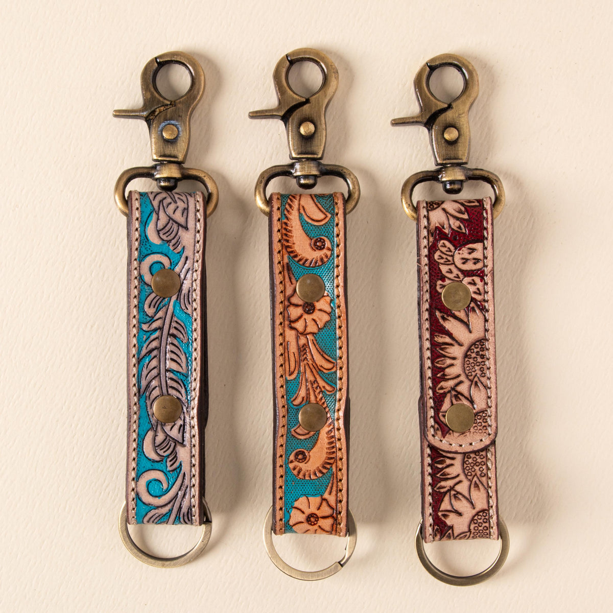 Hand-tooled leather floral keychains with feather, vine and sunflower designs, photo 1