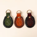 Hand-tooled leather teardrop keychains in forest green, cognac and oxblood with floral medallions and braided edges, photo 1